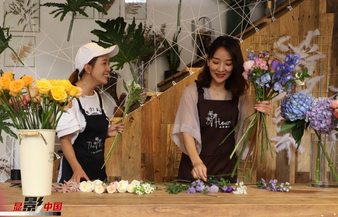 “昆明是鮮花的原產(chǎn)地，有亞洲最大的鮮切花交易市場，可以說具備開花店的天時地利；另外和很多女孩一樣，我從小也就有開花店的夢想！”說起當初的決定，王黎媛說一是因為夢想，另外也跟昆明這個城市產(chǎn)花、賣花的“基因”有關(guān)。圖為王黎媛和同事在制作花束。新華網(wǎng) 周亞平/攝 念新洪/文